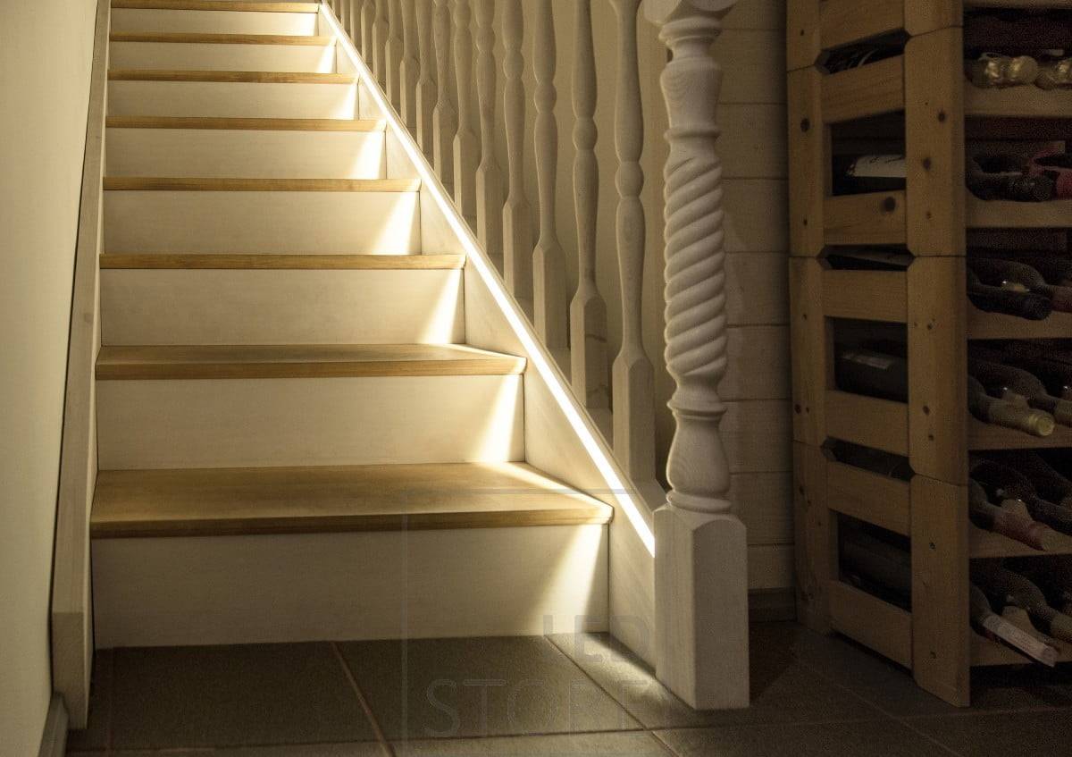Bande de diodes électroluminescentes fraisée dans la rampe d'escalier aussi près que possible de la marche.